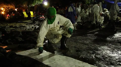 OIL SPILL DISASTER WORKERS NIGHTTIME CLEAN UP Stock Footage 27842727