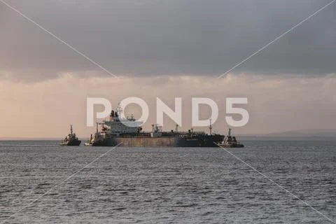 Oil Tanker with tugs in evening light Stock Photos