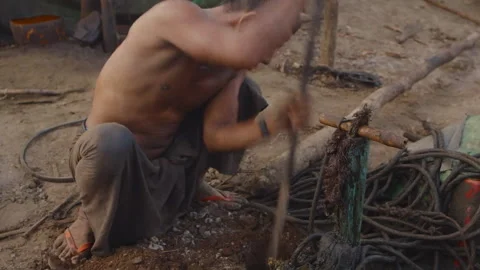 Oil worker digging a hole with a makeshift tool in Myanmar Stock-Footage 332758629