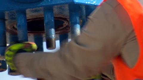 Oil worker tightens nuts on fracking equipment in petroleum field A Stock Footage 125685093