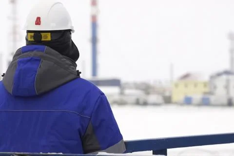 Oil worker view from back looking at gas oil equipment station Stock Photos