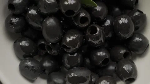 Oiled black pitted olives in macro close up white bowl Vídeos de archivo 334980963