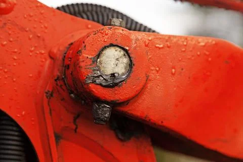 Oiled bolt to large red machine on which it rained Stock Photos