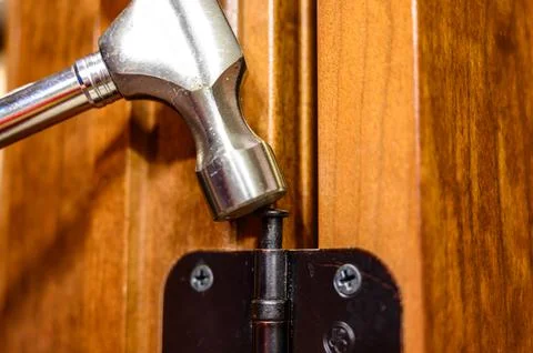 Oiled bronze door hinge with pin being removed Stock Photos