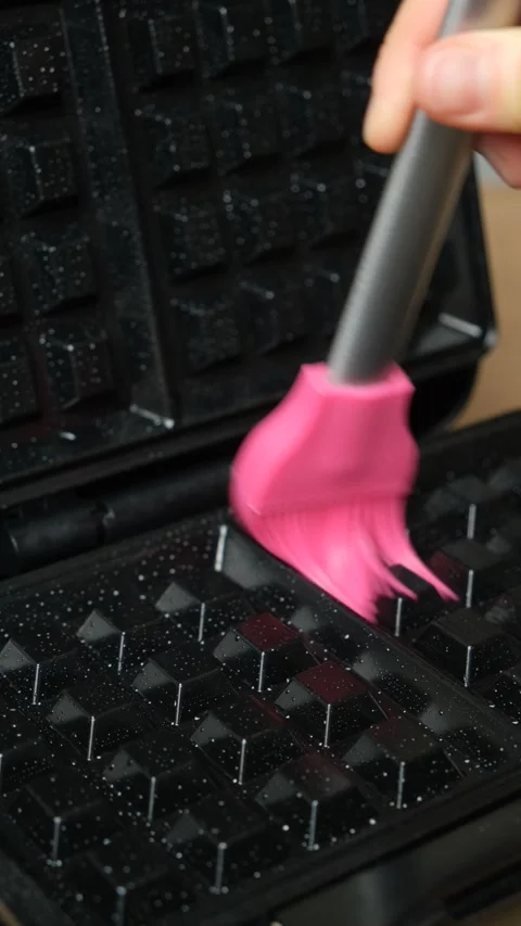 Oiling the surface of the waffle iron, preparing for baking homemade waffles. Stock Footage 324453055
