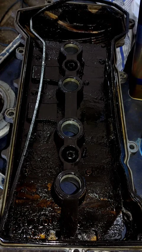Oily engine valve cover with thick sludge and old gasket Stock Footage 334321625