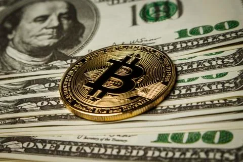 ?oin of bitcoin on a pack of dollars on a table Stock Photos