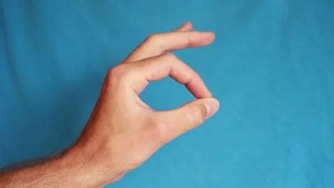 OK gesture demonstrating on blue background Видео 75026247