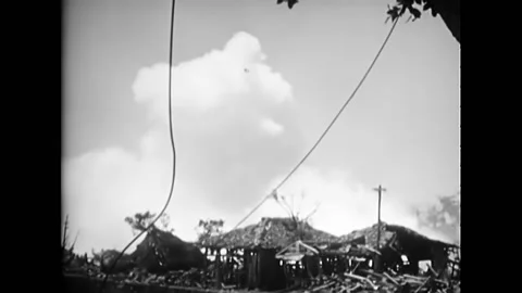OKINAWA - 1945 - Rockets explode in a village in Okinawa, Japan. Stock Footage 287745102