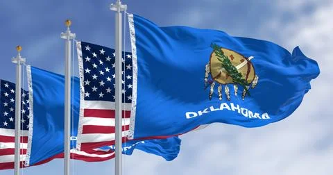 The Oklahoma state flag waving along with the national flags of the US Stock Illustration