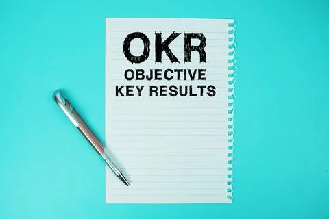 OKR Objective Key Results text written on paper with pen flat lay on blue b.. 스톡 사진