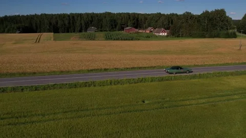 Old 70's historic and unique car driving on green landscapes and roads Stock Footage 230078922