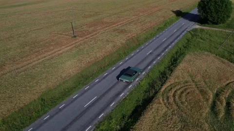 Old 70's historic and unique car driving on green landscapes and roads Stock Footage 230078975