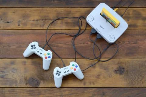 Old 8-bit video game console with game cartridge and two gaming joysticks on  Foto stock