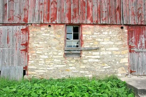 Old abandoned barn with broken window and two wood doors Stock Photos
