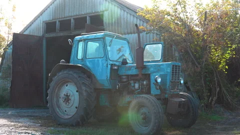 Old abandoned blue tractor. The tractor stands on the background of the hangar. Stock Footage 257932615