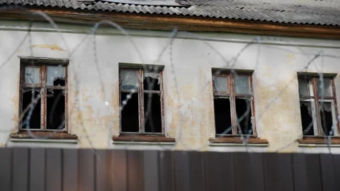 An old abandoned building can be seen behind the barbed wire fence Stock Footage 311762488