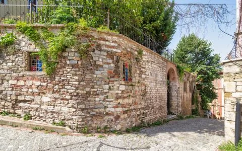 Old abandoned building, with stone wall, wrought iron windows, and climber Stock Photos