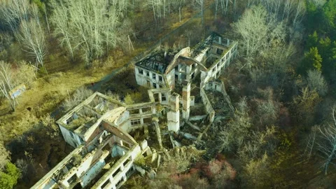 Old abandoned dwelling building without roof and broken windows among green and Stock Footage 165317977