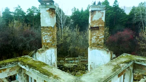 Old abandoned dwelling building without roof and broken windows among green and Video stock 165318025
