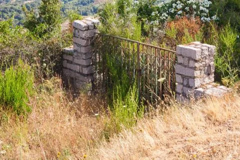 Old abandoned locked stone gate in garden 스톡 사진