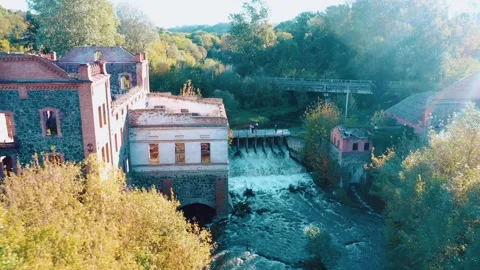 An old abandoned mill by the river. A dilapidated mill by the river with a dam. Stock Footage 288219690