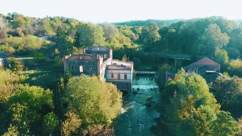An old abandoned mill by the river. A dilapidated mill by the river with a dam. Stock Footage 288219890