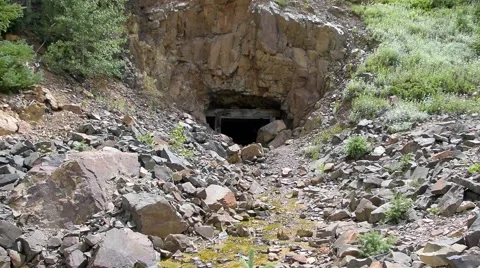 An old abandoned mine cut into the side of a mountain. Stockbeeldmateriaal 53373837