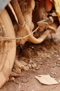 Old abandoned motorcycle with rusty components in the dust Stock Photos