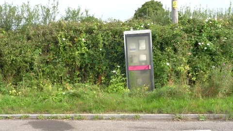 Old abandoned phonebox by the side of the road Stock Footage 78395703