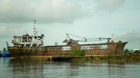 Old abandoned repaired ship or vessel docked on rocky terrain graffiti shipyard Video stock 328745806