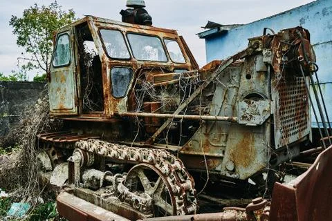 Old abandoned rusty broken tractor. Tractor in a landfill. Stock Photos