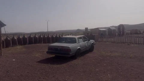 Old abandoned silver sedan parked at rundown desert gas station in Morocco Stock Footage 335963572