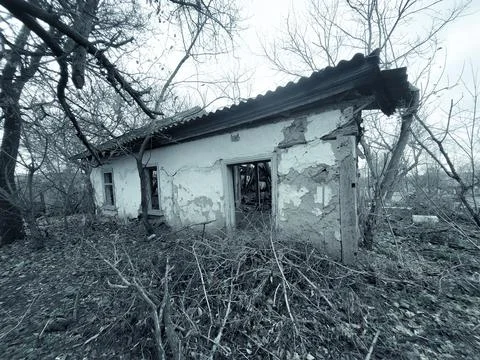 Old abandoned small crumbling rustic house in cold colors. Stock Photos