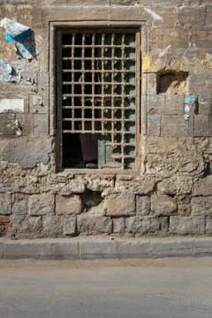 Old abandoned stone bricks wall with one closed grunge broken wooden window Stock Photos