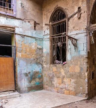 Old abandoned stone bricks wall with one grunge broken wrought iron window Stock Photos