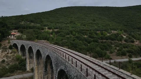 Old abandoned stone train bridge over the river Vidéo 346486670