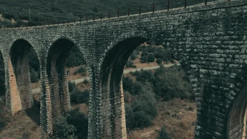 Old abandoned stone train bridge over the river Vidéo 346486688