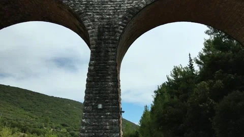 Old abandoned stone train bridge over the river Vidéo 346486818