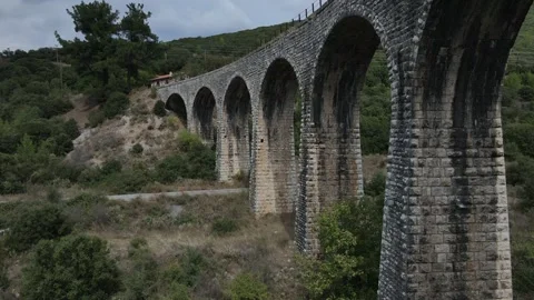 Old abandoned stone train bridge over the river Vidéo 346486883