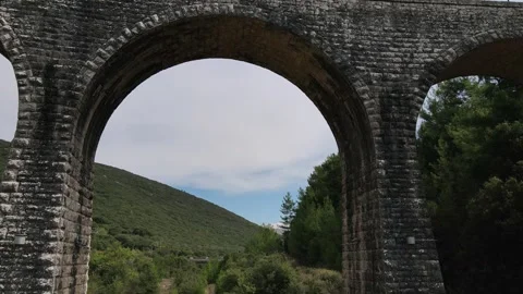 Old abandoned stone train bridge over the river Vidéo 346486900