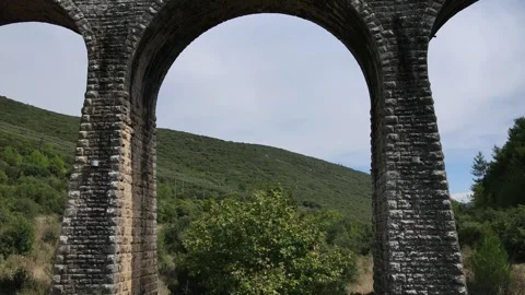 Old abandoned stone train bridge over the river Vidéo 346486942