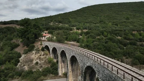 Old abandoned stone train bridge over the river Vidéo 346487069