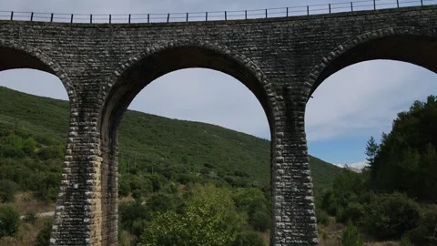 Old abandoned stone train bridge over the river Vidéo 346487081