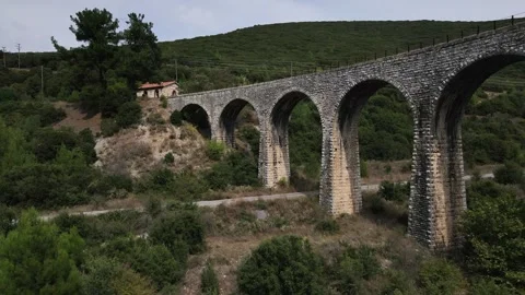 Old abandoned stone train bridge over the river Vidéo 346487172