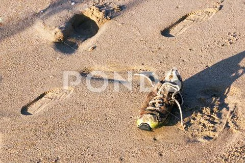 Old Abandoned Wet Dirty Shoe on Beach Sand Stock Photos