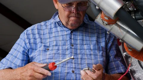 Old aged man is fixing aircraft engine details with the screwdriver Stock-Footage 116773750