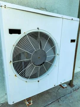 Old air conditioning unit mounted on a wall outside a building Stock Photos