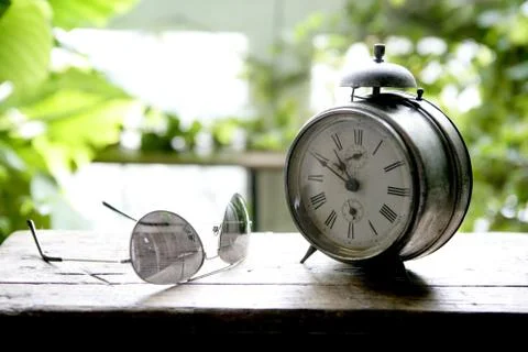 Old alarm bell clock at the window backlit Stock Photos