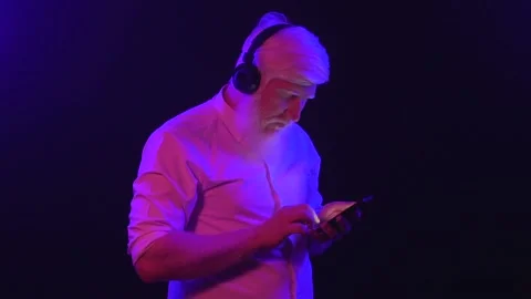 An old albino grandpa dancing while wearing new earphones and changing songs  Stock Footage 137515531